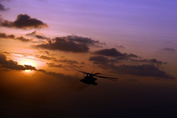 Hubschrauber auf dem Hintergrund eines schönen Sonnenuntergangs