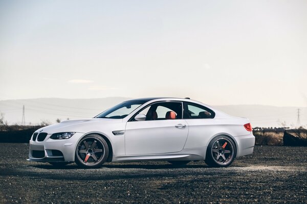 BMW blanco de lado contra un cielo claro