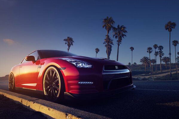 Red Nissan at sunset and palm trees