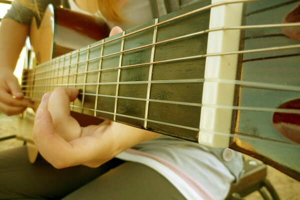 Manche de guitare. Cordes de guitare. Guitariste. Accord. Fille avec une guitare