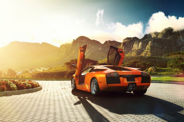 Orange lamborghini murcielago on the background of mountains