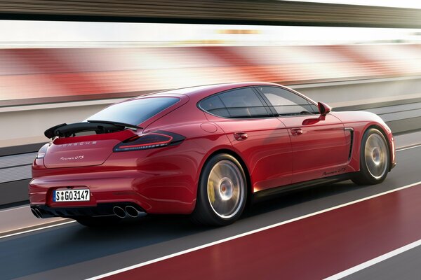 Porsche Panamera rojo conduce por la carretera