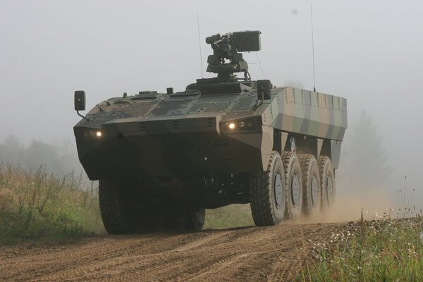 Armored personnel carrier in action rushes along the road