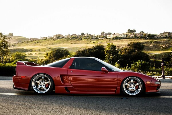 Cherry-colored car in profile with spoiler