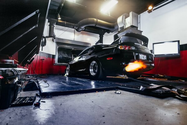 Toyota supra in der Garage mit Flammenzungen aus dem Auspuffrohr