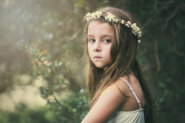 A sad girl is sitting in a wreath