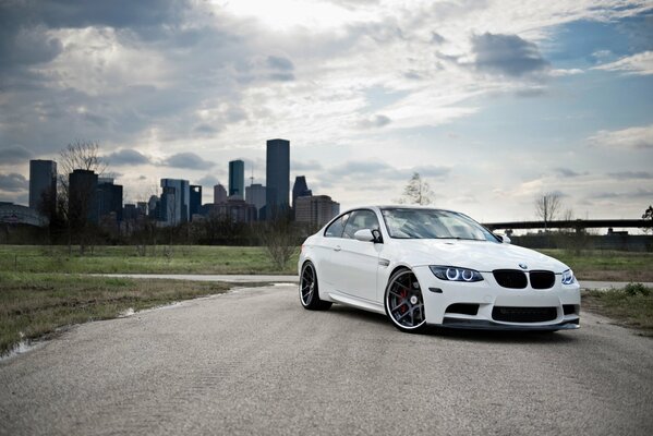 White BMW M3 in the back of the e92 on the background of the city