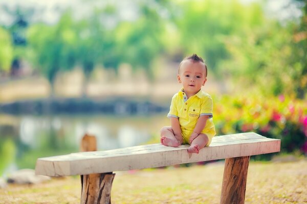 Симпатичный малыш на скамейке в парке