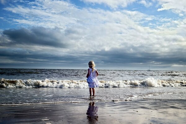 Fille regardant au loin dans la mer