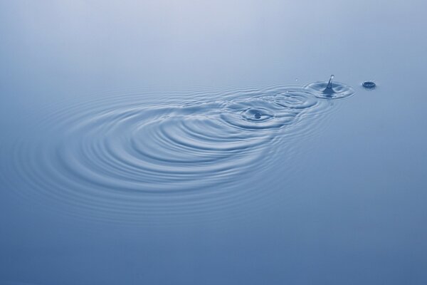 Falling drops in blue water