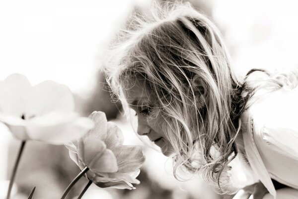 A girl sniffs a beautiful flower