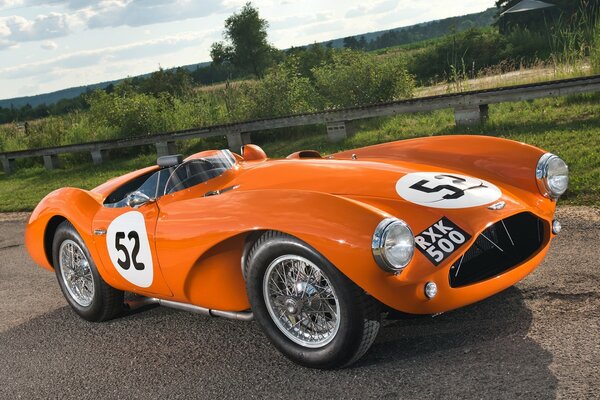 Aston Martin orange sur la route rurale