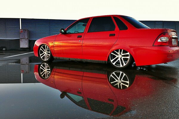 Red understated priora on wet asphalt