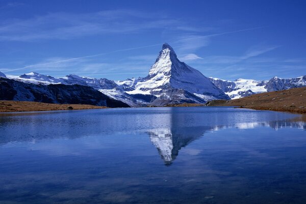 A huge snow mountain is reflected in the lake