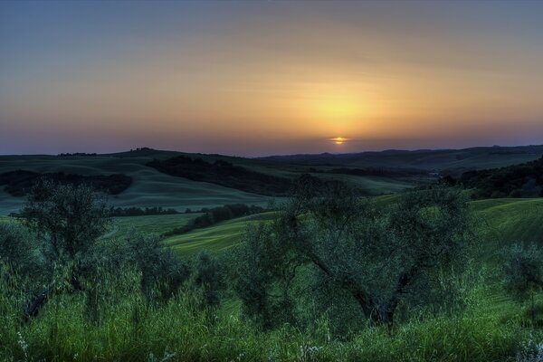 Puesta de sol sobre la llanura verde italiana