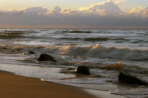 Splashes of waves in the surf fall on the rocks