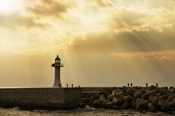 Lighthouse in the sun and fishermen