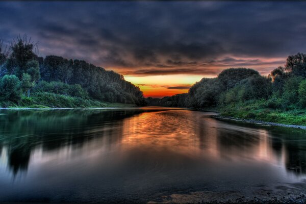 Nuages sur les rives de la rivière au coucher du soleil