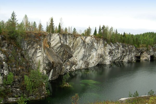 Ruskeala-marble canyon, Karelia. A river with a rocky shore overgrown with forest