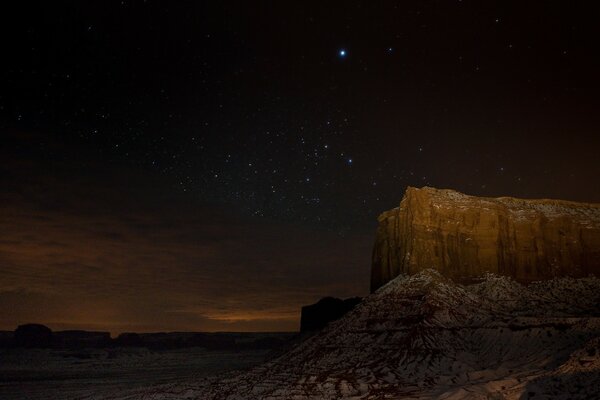 La roca sigue el desierto en una noche estrellada