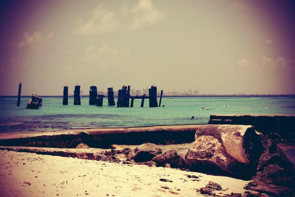 Destroyed sea pier on the beach