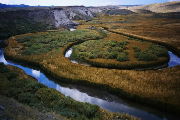 The riverbed skirts the mountains and fields