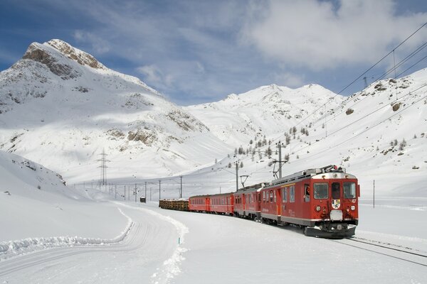 Red train in winter in the mountains