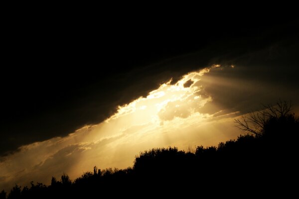 The rays of the sun peek out of a dark cloud