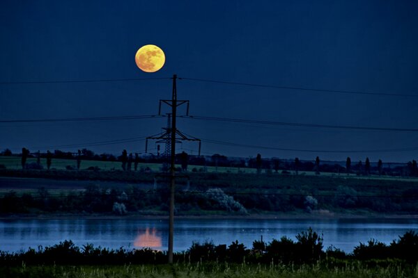 A mystical landscape with the moon reflected in the water