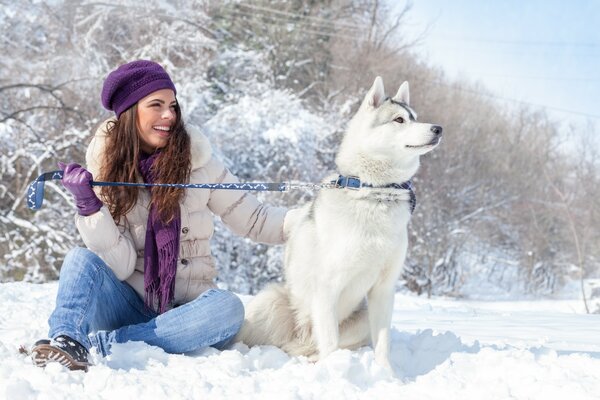 Dziewczyna z psem rasy husky zimą