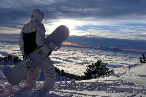 Snowboardzista na zboczu góry na tle pięknego nieba