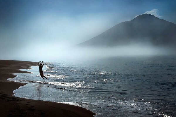 Homme au bord de la mer sur fond de rochers