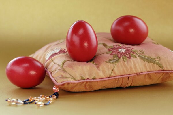 Uova rosse di Pasqua sul cuscino