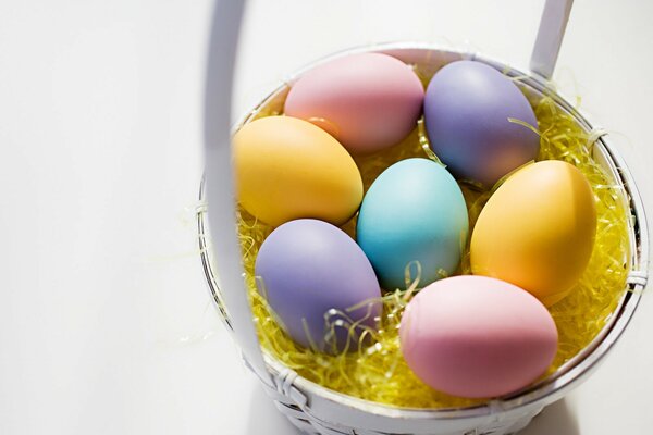 Cesta blanca con huevos de colores