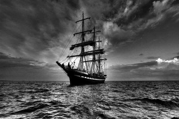 Foto en blanco y negro con la nave por el mar y el cielo