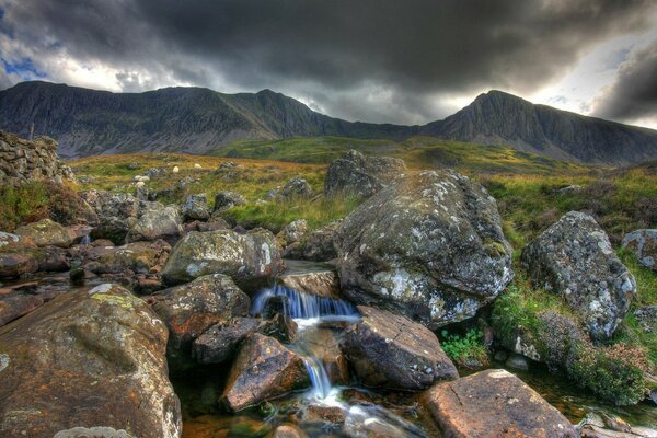 Rivière de montagne sur fond de montagnes et ciel sombre