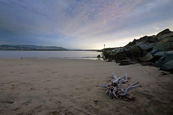 Tramonto sulla spiaggia rocciosa deserta