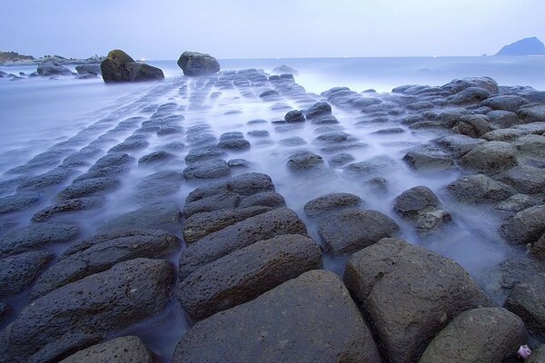 Mar con piedras en la niebla