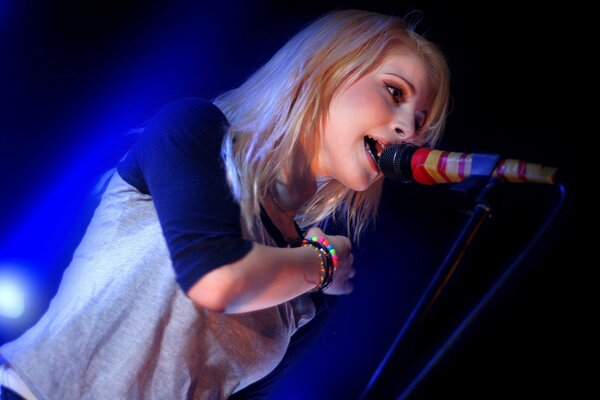 A girl sings in a color microphone