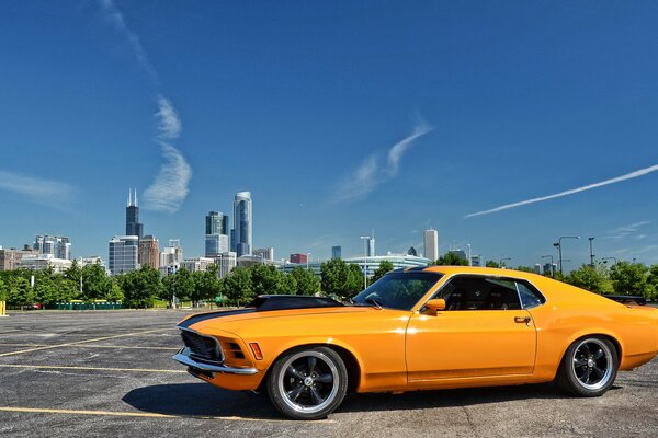 Yellow Ford Mustang on the background of the city