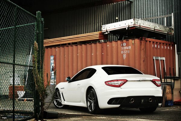 A white maserati is coming in for repairs