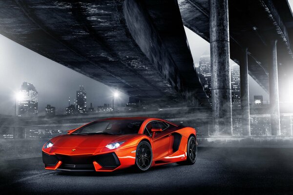 Lamborghini naranja a la luz de la ciudad nocturna
