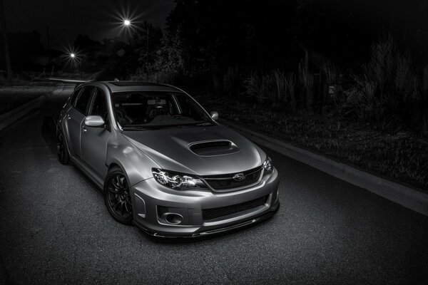 Carrera en medio de una noche sombría en un coche gris