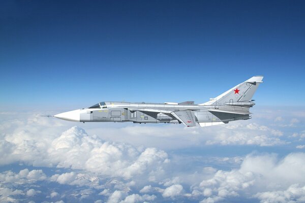 Bombardero su-24 vuela en el cielo sobre las nubes