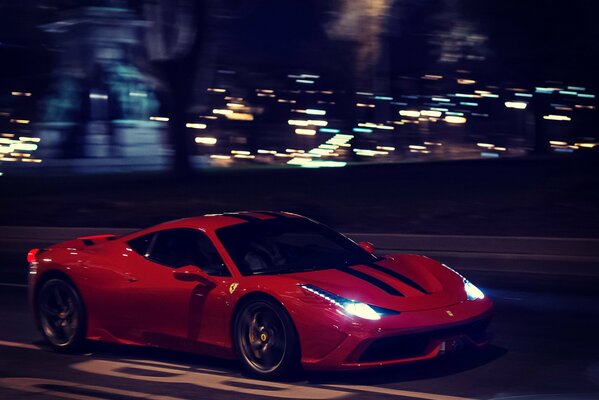Czerwone Ferrari w nocy jeździ po torze