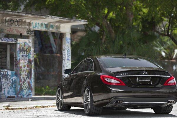 Black Mercedes on the background of a building painted with graffiti