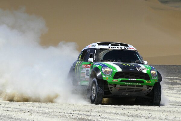 El coche verde mini cooper en el polvo de la participación en el Rally