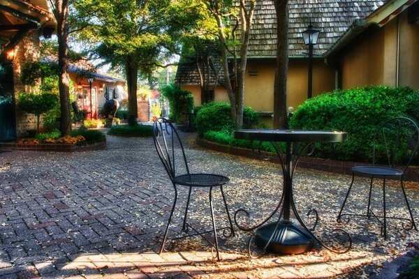 Table et chaises sur le trottoir près de la maison