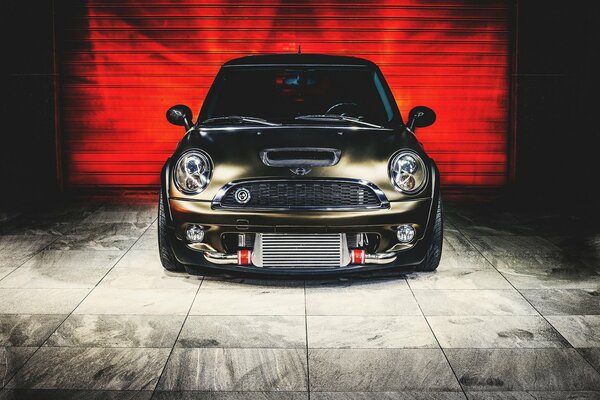 Mini cooper on the background of red garage doors