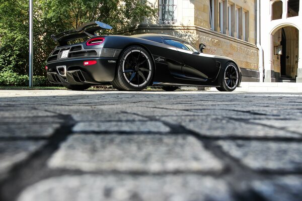 Black Koenigsegg agera r. standing on the asphalt